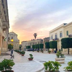 une rue urbaine vide avec des bâtiments et des plantes en pot dans l'établissement Casa Regina Elena - Locazione Turistica, à San Cesario di Lecce