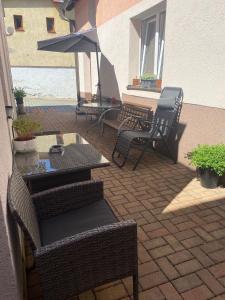 eine Terrasse mit Stühlen, einem Tisch und einem Sonnenschirm in der Unterkunft Penzion Pod Ždánovem in Nezdice