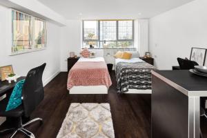 a bedroom with two beds and a desk at Cosy Studios and Apartments at Chapter Aldgate in London in London