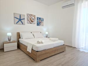 una camera bianca con un letto con due asciugamani di LT VISTA MARE -Baia Verde- Gallipoli a Gallipoli