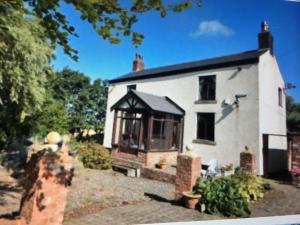 a small white house with a large window at Rural Family Farmhouse with Countryside views in Southport