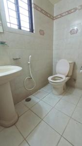 a white bathroom with a toilet and a sink at Hotel Skylink in Dhaka