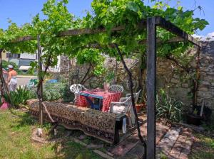 a pergola with a table and chairs under a tree at Budget Cozy in Pula