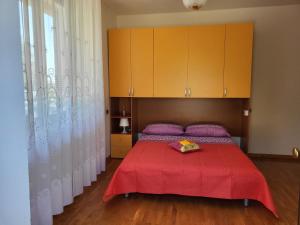 a bedroom with a red bed with a red blanket at COLLINA FIORITA in Tollo