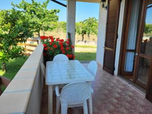 - une table et deux chaises sur une terrasse couverte fleurie dans l'établissement COLLINA FIORITA, à Tollo