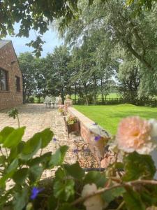 un jardín con flores y una pared de ladrillo y un edificio en Rural Family Farmhouse with Countryside views en Southport