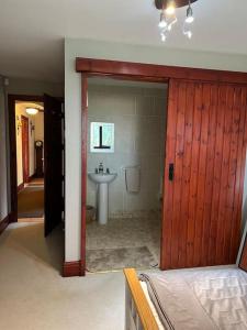 La salle de bains est pourvue d'un lavabo et d'une porte en bois. dans l'établissement Rural Family Farmhouse with Countryside views, à Southport