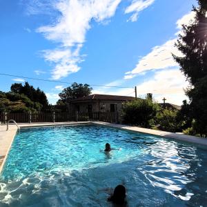 una persona nadando en una piscina en Casa de Casal, en Lestedo