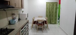 una cucina con tavolo, sedie e frigorifero di Homestay Merbau Bandar Putra Kulai a Kulai