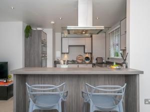 a kitchen with two chairs sitting at a counter at Cosy Modern Flat Pass The Keys in Edinburgh