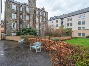 two blue benches sitting in front of a building at Cosy Modern Flat Pass The Keys in Edinburgh