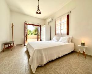 ein Schlafzimmer mit einem großen weißen Bett und einem Fenster in der Unterkunft George's gorgeous house Anavysos in Anavyssos