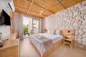 sypialnia z łóżkiem i kamienną ścianą w obiekcie Melisa Boutique Hotel & Spa w Kaş