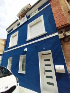 una casa azul con un coche blanco aparcado delante en Casa Petits en Manresa