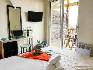a bedroom with a bed with a mirror and a table at VVF Narbonne-Plage Saint-Pierre-la-Mer in Fleury