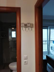 テッサロニキにあるmodern&comfortable apartment Euosmos Thessalonikiのトイレと壁に標識のある浴室