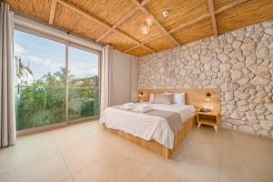 a bedroom with a bed and a stone wall at Melisa Pansiyon in Kas