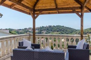 a balcony with blue and white chairs and a wooden roof at Villa Luxury piscina y cascada 2 min de la playa in Lloret de Mar