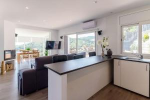 a kitchen and living room with a table and chairs at Villa Luxury piscina y cascada 2 min de la playa in Lloret de Mar