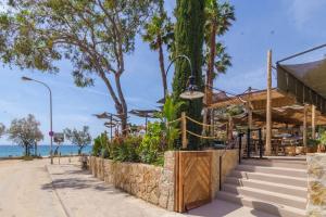 a building on the beach with trees and the ocean at Villa Luxury piscina y cascada 2 min de la playa in Lloret de Mar