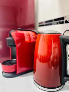 a red coffee mug sitting next to a toaster at Neuwertiges Apartment mit schnellem WLAN, Glasfaser, Kostenlose Privatparkplatz auch für Transporter geeignet R20 in Freiberg am Neckar