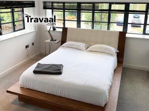 Wallis Square في فارنبورو: غرفة نوم مع سرير كبير مع ملاءات بيضاء ونوافذ