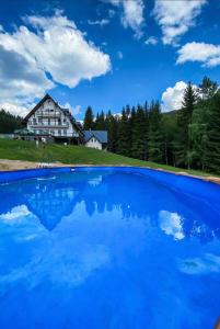 een blauw zwembad voor een huis bij Premium Apartment Rokytnice in Rokytnice nad Jizerou