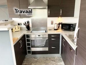 a kitchen with a stove and a microwave at Wallis Square in Farnborough