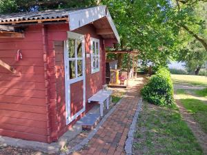 a red tiny house with a bench in a yard at Sommersitz in Hohnstorf