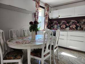 cocina con mesa blanca y sillas blancas en Ferienhaus Ani, en Patzig