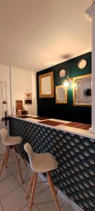 - un bar avec deux chaises et un comptoir avec des miroirs dans l'établissement Studio, TopdestinationBretagne, à Montoir-de-Bretagne