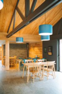 a dining room with wooden ceilings and blue lights at Huttopia Baie du Mont Saint Michel in Baguer-Pican