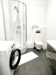 ein Bad mit einer Dusche und einer Waschmaschine in der Unterkunft Old Town Szczecin in Stettin