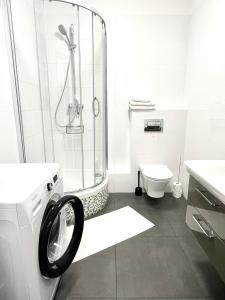 y baño con ducha y lavadora. en Old Town Szczecin, en Szczecin