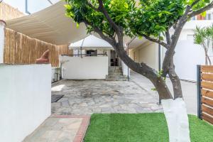 a courtyard with a tree in a house at Exotic House Close to the Beach in Gázion