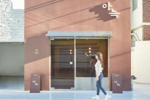 a woman walking in front of a building at The Hyoosik Aank Hotel Busan Nampo Branch in Busan