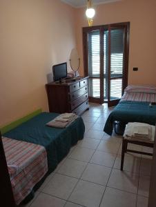 een slaapkamer met 2 bedden en een dressoir met een spiegel bij Casa Vacanze La Notte in Spello