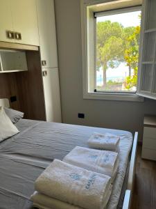 una camera da letto con tre asciugamani su un letto con finestra di Villa Cataleya a Praia a Mare