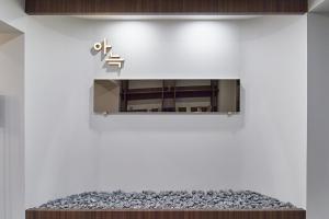 un cartel en una pared sobre un sofá en Aank Hotel Busan Nampo, en Busan