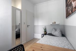 een kleine slaapkamer met een bed en een spiegel bij Haus KÖ 17 in Norderstedt