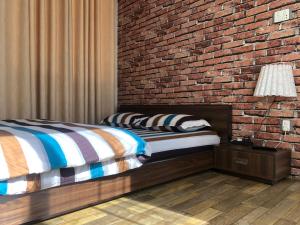 a bedroom with a brick wall and two beds at NhuChhe Apartments in Pātan