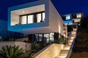 ein Haus mit einer blau-weißen Fassade in der Nacht in der Unterkunft Villa Infinity - Luxurious seaview Villa with enchanting Pool in Kali