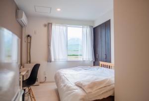 sypialnia z łóżkiem i oknem w obiekcie Niseko Hirafu Ski Resort Condo w mieście Kutchan