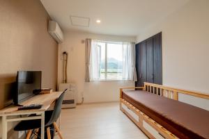 a bedroom with a bed and a desk and a television at Niseko Hirafu Ski Resort Condo in Kutchan