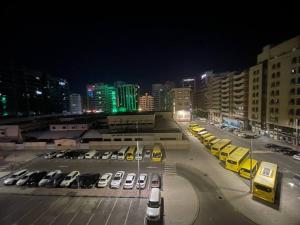a parking lot with parked cars in a city at night at Master Bed Room with Balcony Shared Apartment AUH UAE in Abu Dhabi