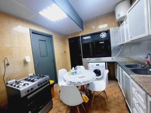 uma pequena cozinha com uma mesa e um fogão em Master Bed Room with Balcony Shared Apartment AUH UAE em Abu Dhabi
