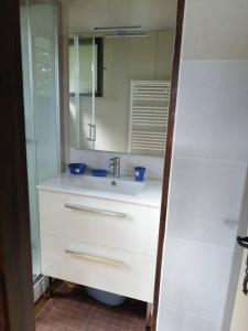 a white bathroom with a sink and a mirror at haut de chalet le Bois de Cerf in Les Angles