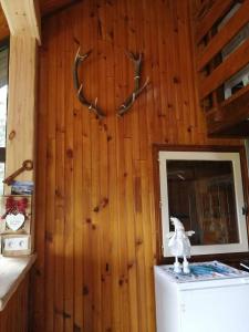 a room with a refrigerator and antlers on a wall at haut de chalet le Bois de Cerf in Les Angles