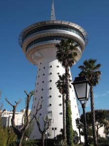 una torre de control con palmeras frente a un edificio en Villa climatisée proche mer Carnon Pérols en Pérols