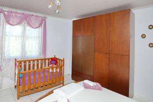 a bedroom with a crib and a wooden cabinet at DIANA'S HOUSE in Khrisókastron +18 photos